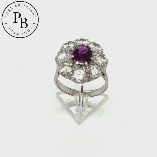 A natural oval ruby weighing 1ct. No evidence of heat treatment. With eight natural old cut round brilliant cut diamonds total weight 2.40ct Colour G SI all mounted in 18ct white gold. The ring  weighing 7.30 grams is stamped 18ct